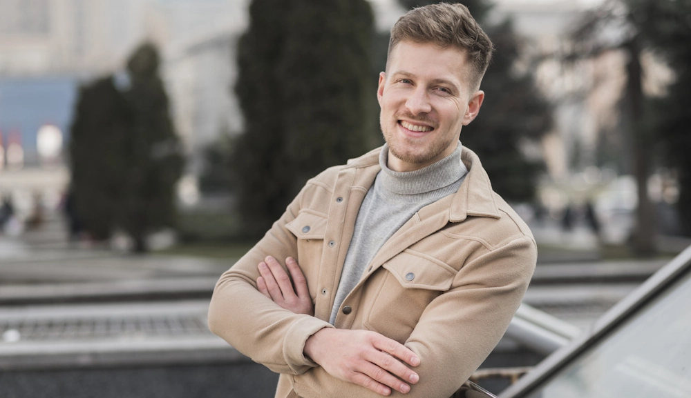 Усміхнений чоловік у місті — приклад впевненості після корекції гінекомастії з підтяжкою